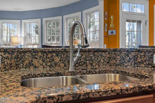 a kitchen with stainless steel appliances granite countertop a stove top oven a sink dishwasher a refrigerator and cabinets with wooden floor