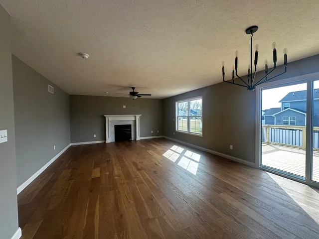 a view of empty room with wooden floor and fireplace