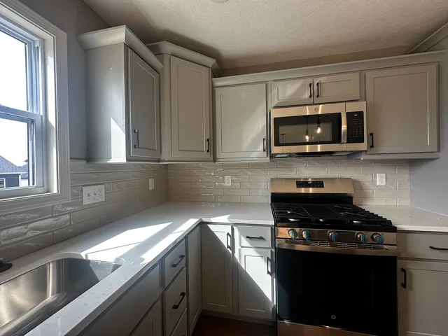 a kitchen with a sink and steel appliances