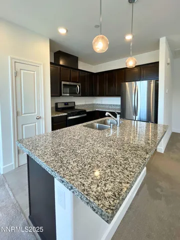 a kitchen with stainless steel appliances granite countertop a sink refrigerator and microwave