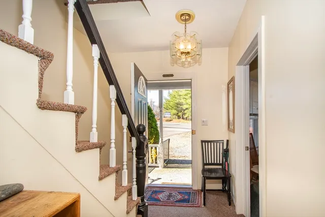 a view of a livingroom with furniture staircase and front door
