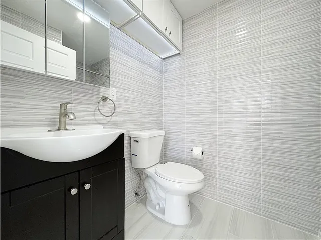 a bathroom with a sink a toilet and mirror