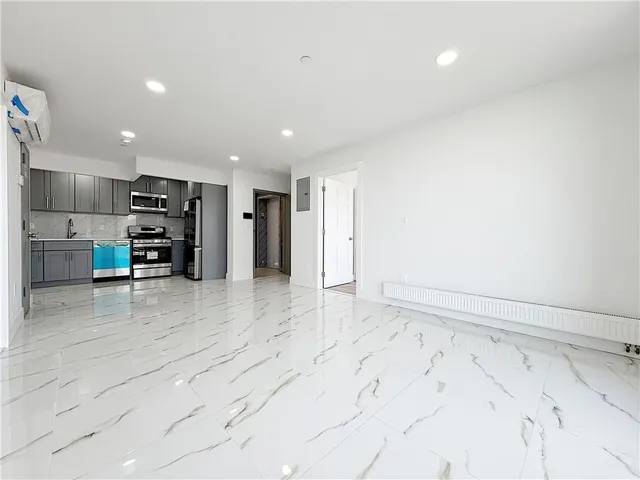 an empty room with a kitchen space and a window