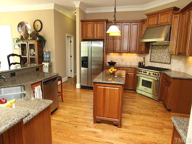 2604 Sunbriar Lane Raleigh, NC 27613 - Photo 4 of 25 Granite counters ... 6 Burner Wolf cooktop with up and down draft exhaust. Butlers pantry and walkin pantry ..beautiful stained cabinets and hardwoods, tile backsplash, soft close drawers on work island