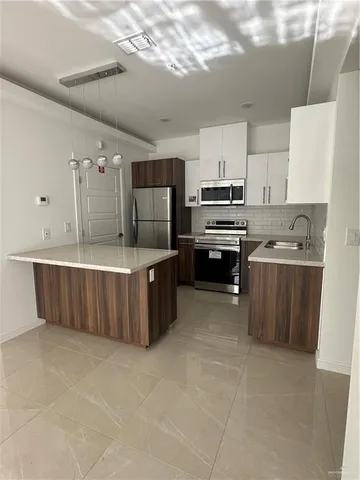 a kitchen with kitchen island a counter top space appliances and cabinets