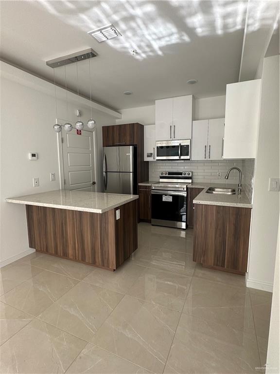 901 Yuma Avenue, Unit 202 McAllen, TX 78503 - Photo 3 of 11 a kitchen with kitchen island a counter top space appliances and cabinets