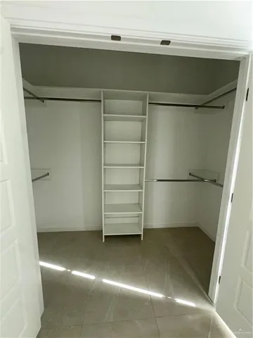 a view of walk in closet with empty racks