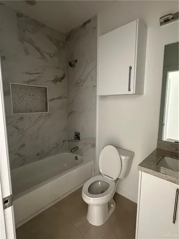 a bathroom with a granite countertop toilet a sink and bathtub
