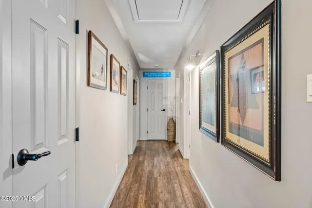 a view of a hallway with wooden floor and staircase