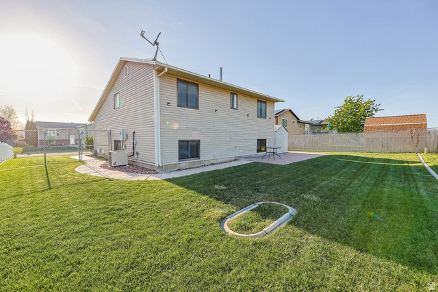 5896 South 3950th Street West Roy, UT 84067 - Photo 25 of 29 Back of house featuring a fenced backyard and a patio area