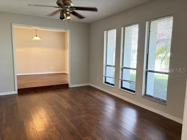 a view of an empty room with wooden floor and a window
