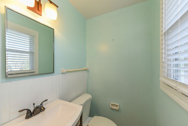 a bathroom with a sink a toilet and a window