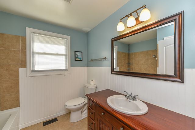 a bathroom with a toilet a sink and mirror