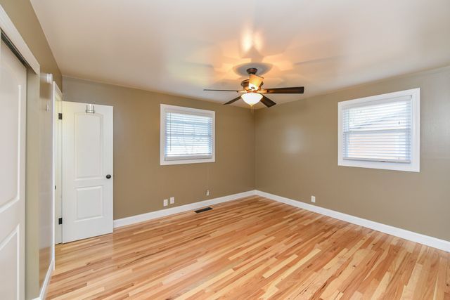 a view of a room with wooden floor and fan