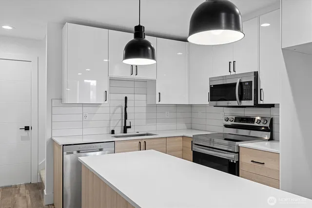 a kitchen with stainless steel appliances a stove a microwave and a sink