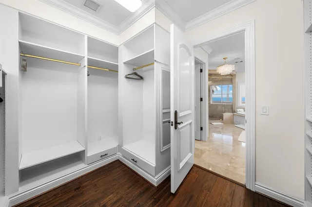 a view of walk in closet with empty racks