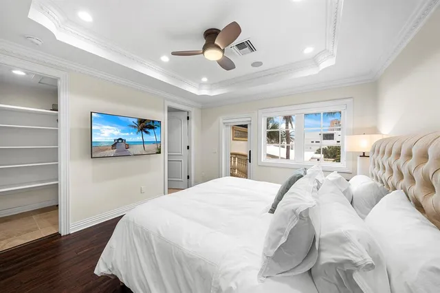 a bedroom with a bed and a flat tv screen on dresser