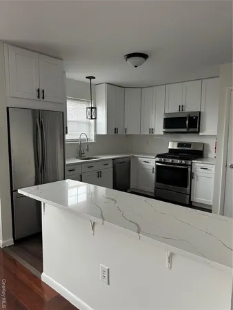 a kitchen with kitchen island a counter top space stainless steel appliances and cabinets