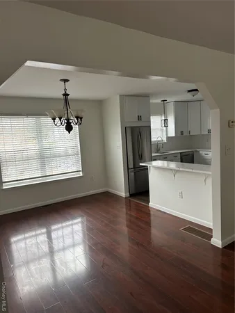 a kitchen with stainless steel appliances wooden floor and a large window