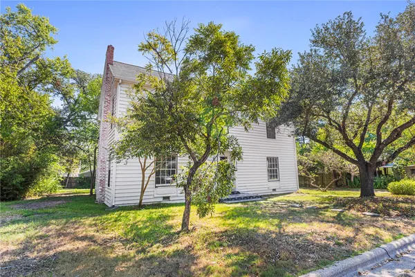 a backyard of a house with a garden and tree