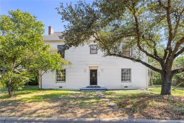 a house that has a tree in front of the house