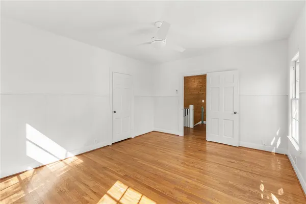 a view of an empty room with wooden floor