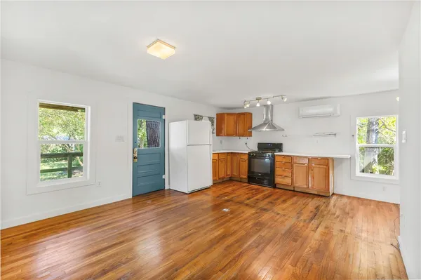 a kitchen with wooden floors and natural light