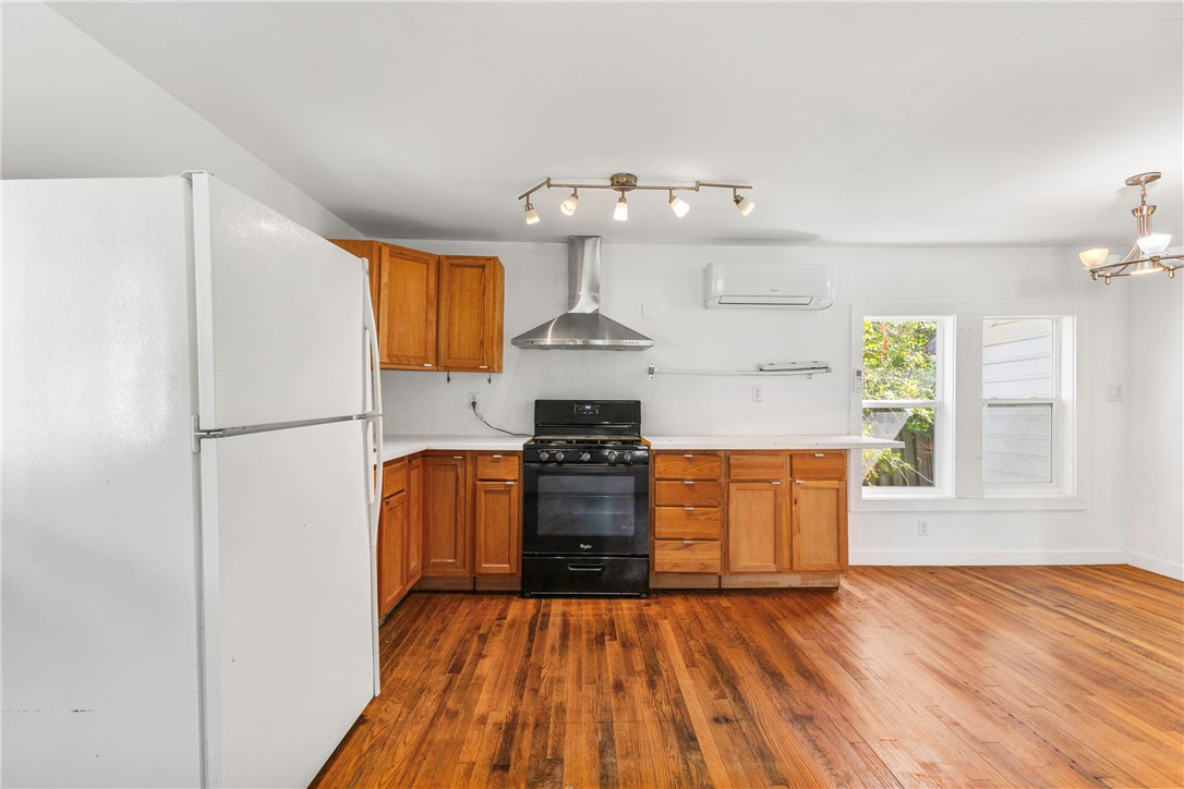 712 Banks Street Bryan, TX 77803 - Photo 28 of 33 a kitchen with granite countertop wooden floors stainless steel appliances and a window