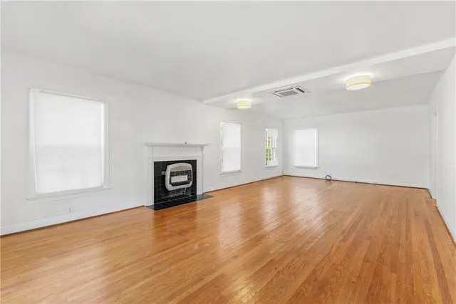 an empty room with wooden floor and fireplace