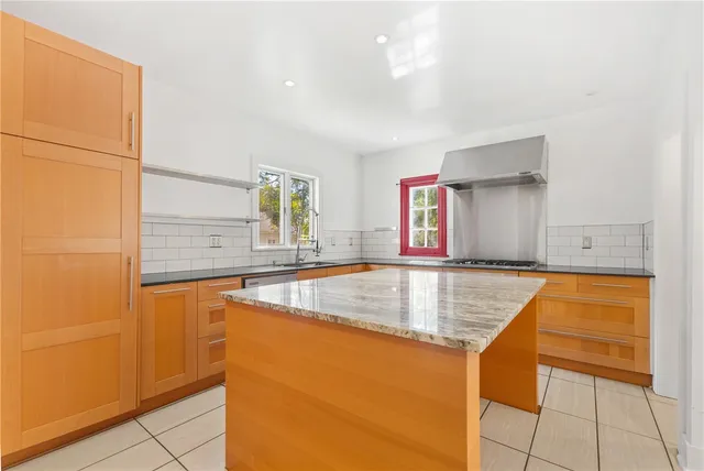a kitchen with stainless steel appliances granite countertop a sink and a refrigerator