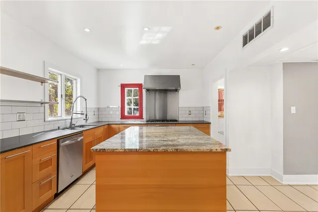 a kitchen with stainless steel appliances granite countertop a sink and a stove