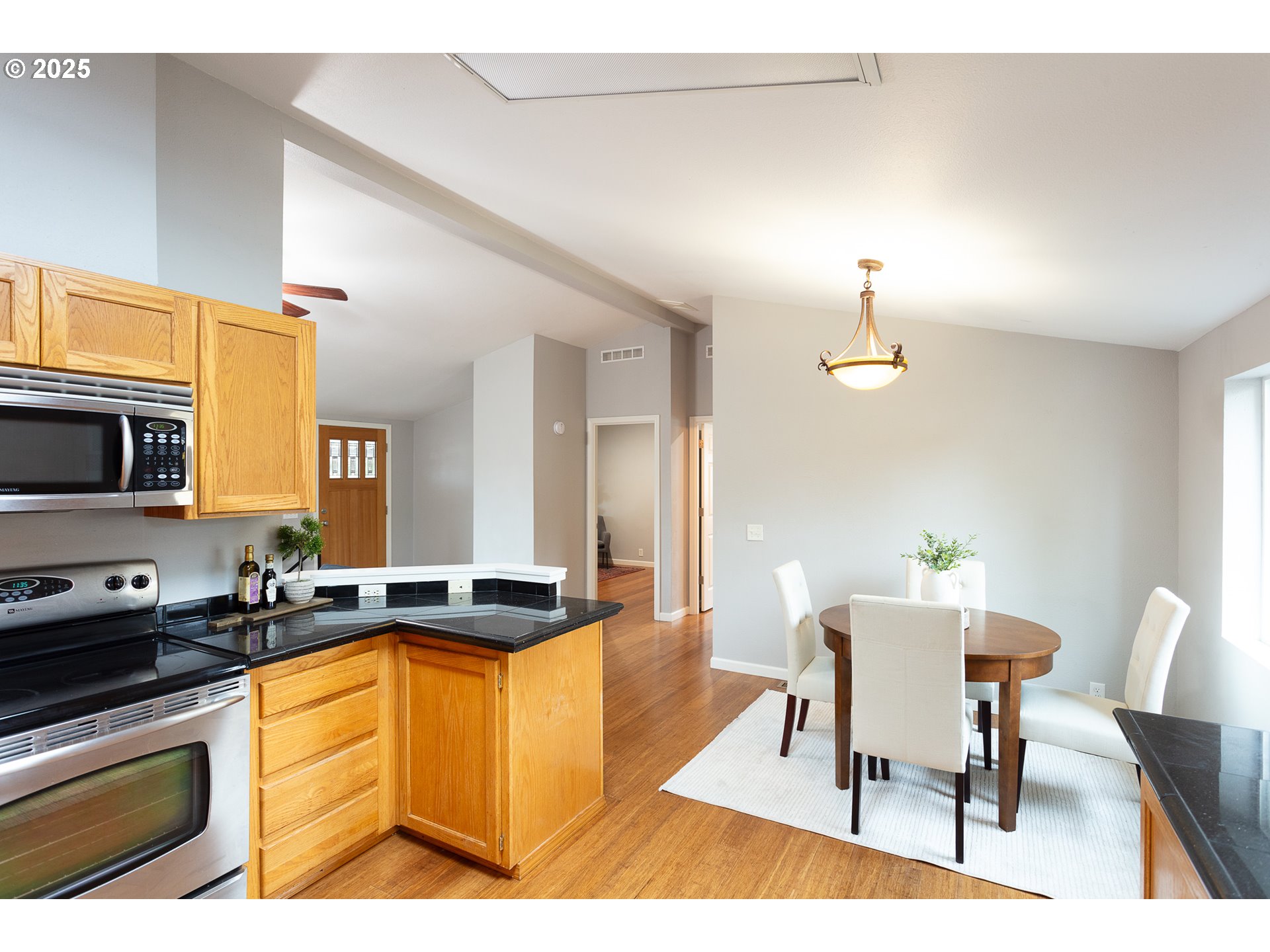 2655 Atticus Way Eugene, OR 97404 - Photo 11 of 27 a kitchen with granite countertop a stove a sink a dining table and chairs