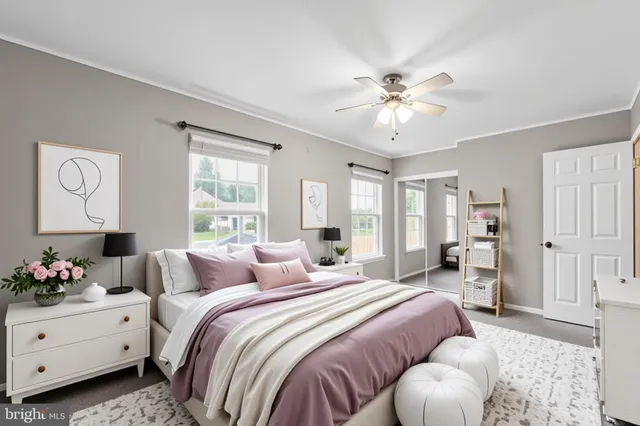 a bedroom with a bed and a chandelier fan