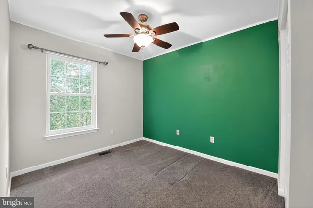 a view of a big room with windows and ceiling fan