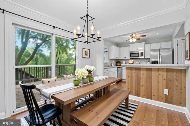 a dining room with furniture a chandelier and wooden floor