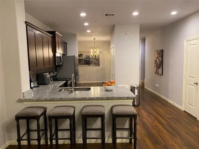 a kitchen with stainless steel appliances granite countertop a sink and cabinets