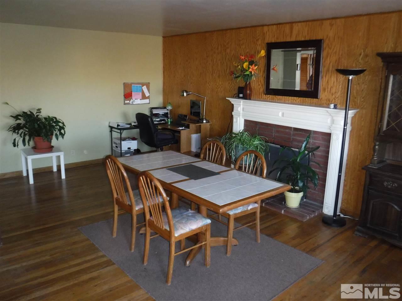 2015 Ives Avenue Reno, NV 89503 - Photo 9 of 21 a dining room with furniture wooden floor a fireplace and a painting