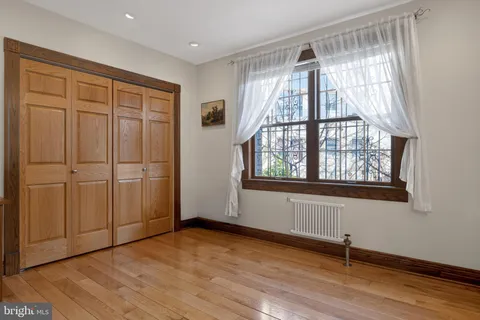 a bedroom with a bed and a flat tv screen on dresser