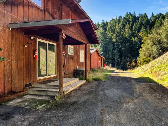 a view of a house with backyard and trees
