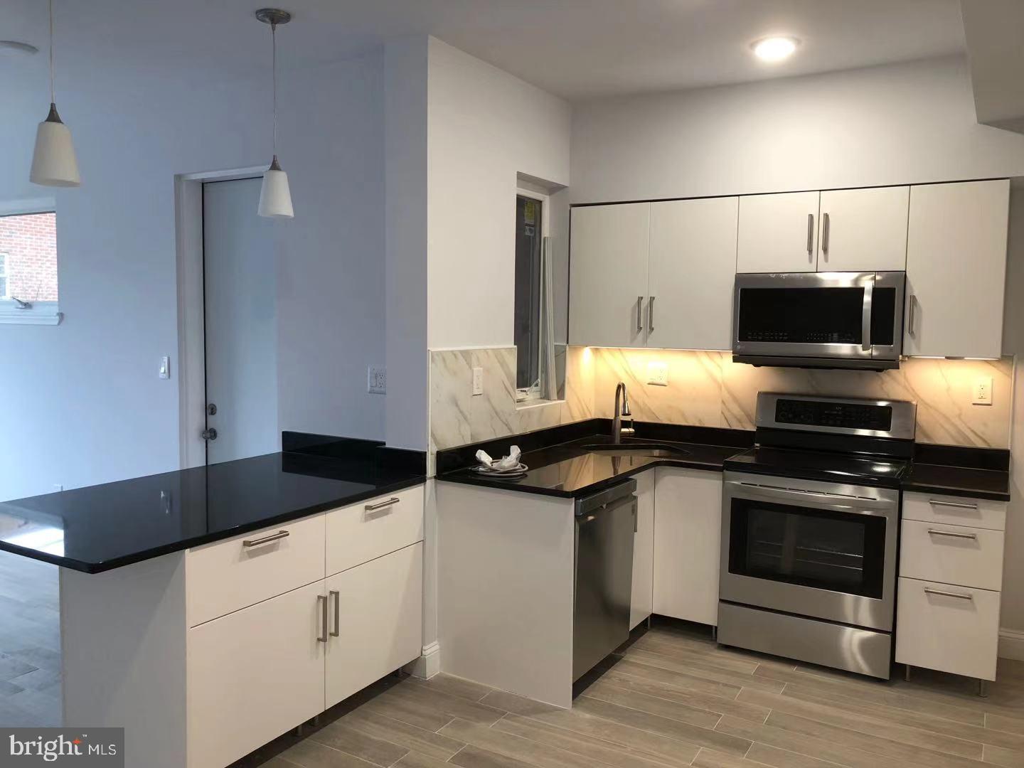 1008 Green Street Philadelphia, PA 19123 - Photo 25 of 40 a kitchen with stainless steel appliances granite countertop a sink and a stove