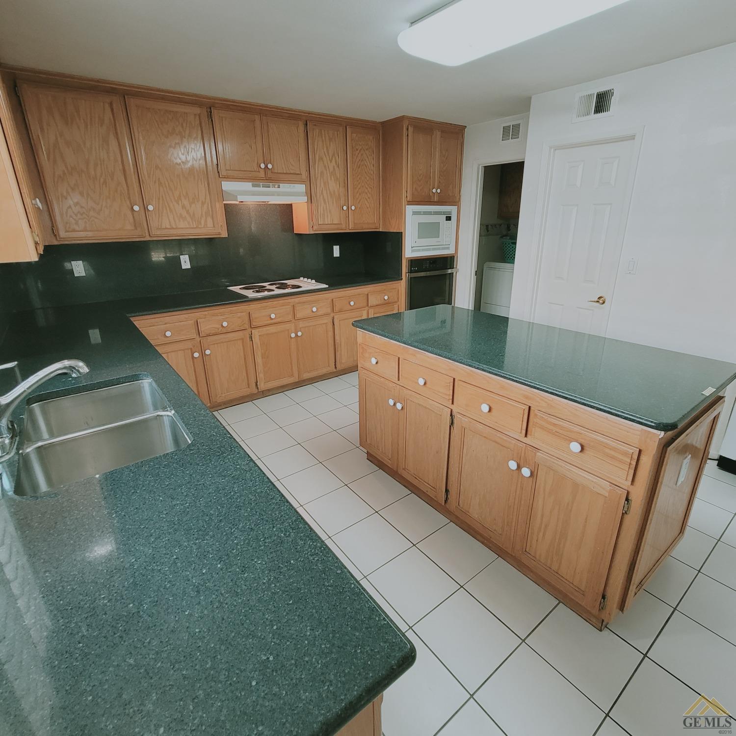 Undisclosed Address Bakersfield, CA 93313 - Photo 5 of 24 a kitchen with granite countertop a sink a stove top oven and cabinets