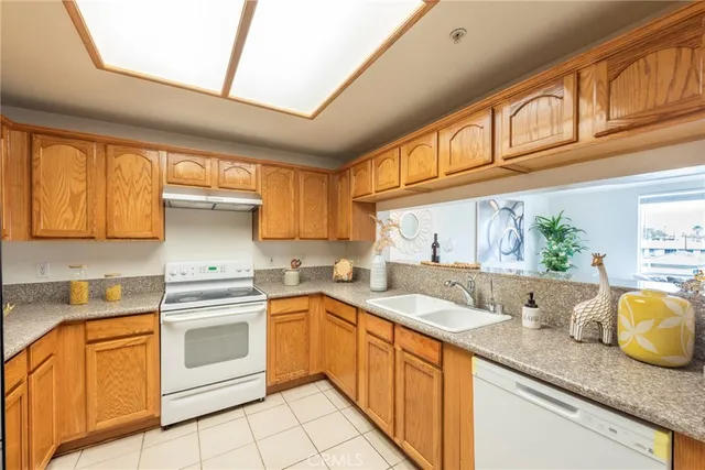 a kitchen with stainless steel appliances granite countertop a sink a stove cabinets granite counter tops and a window