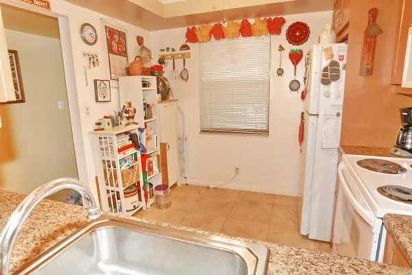 a utility room with fridge and sink