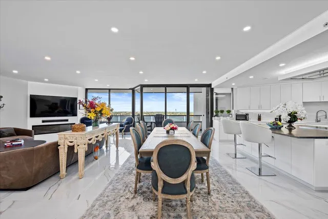 a living room with stainless steel appliances furniture and a flat screen tv
