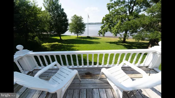 a view of a wooden chairs and bench in the garden