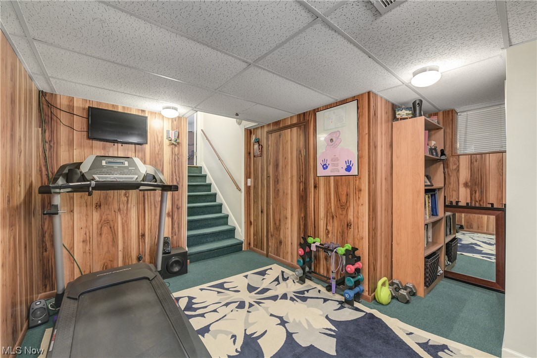 7094 Brandywine Road Parma Heights, OH 44130 - Photo 45 of 49 Workout room featuring dark carpet, a drop ceiling, and wooden walls