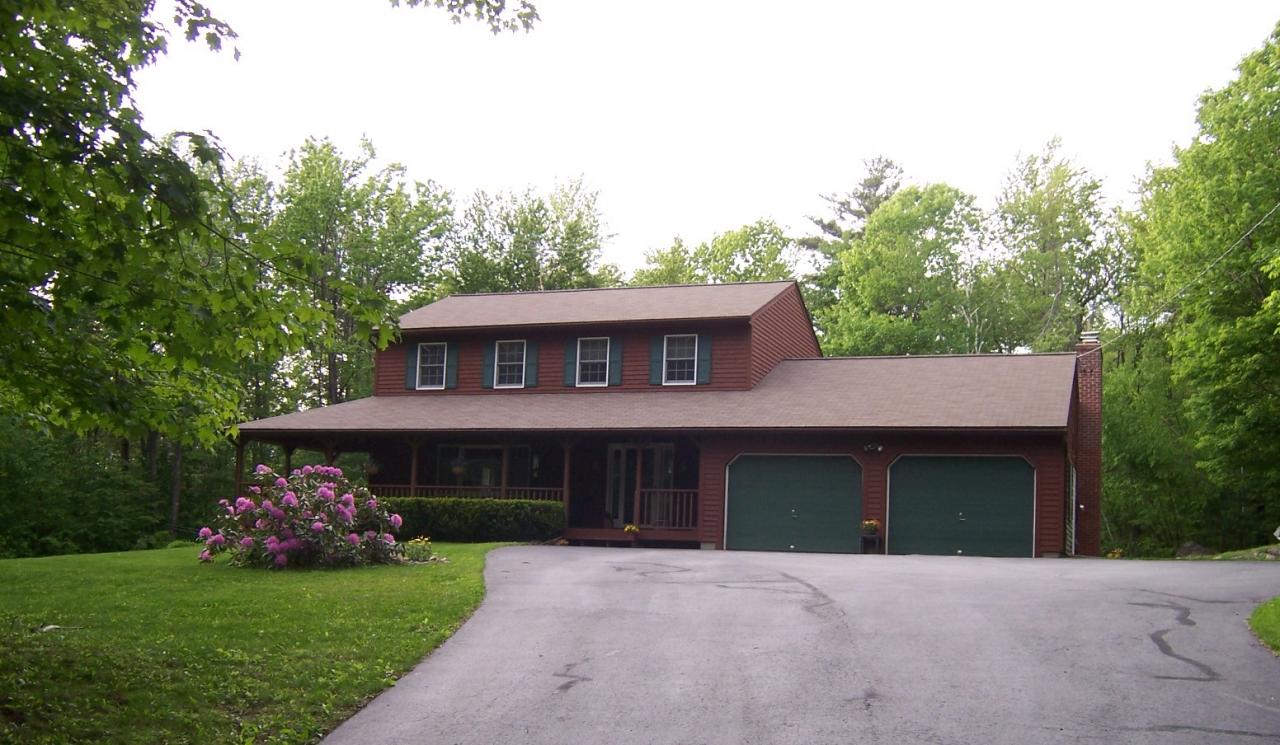 1304 George Carter Road Becket, MA 01223 - Photo 1 of 12 a front view of a house with a garden