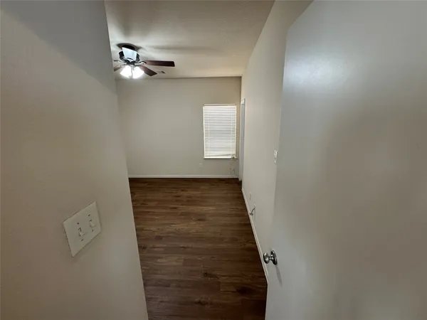 a view of a room with wooden floor and fan