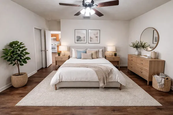 a bedroom with a bed lamp and a potted plant