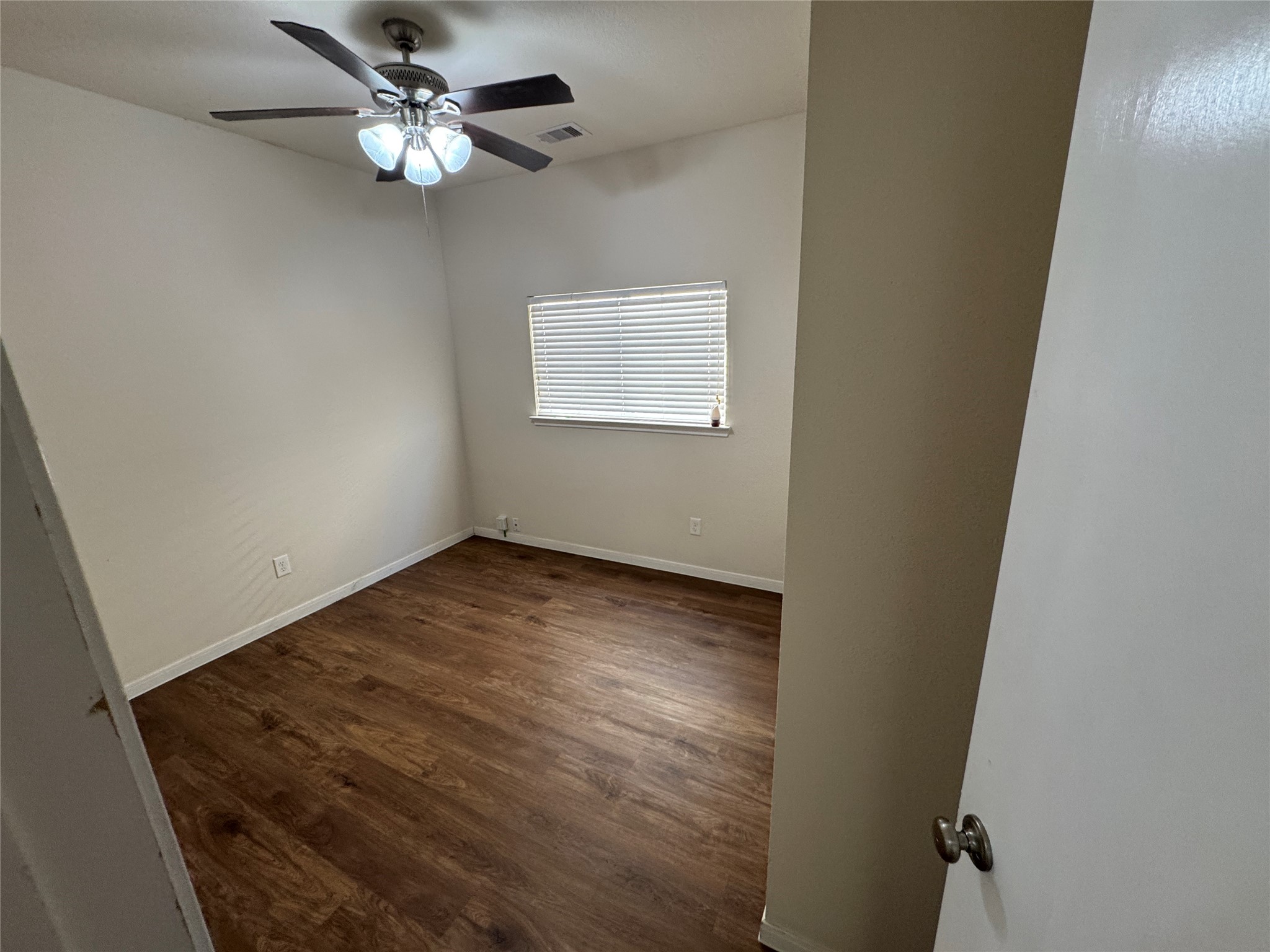 21719 Mossy Field Lane Spring, TX 77388 - Photo 32 of 44 an empty room with a chandelier fan and wooden floor